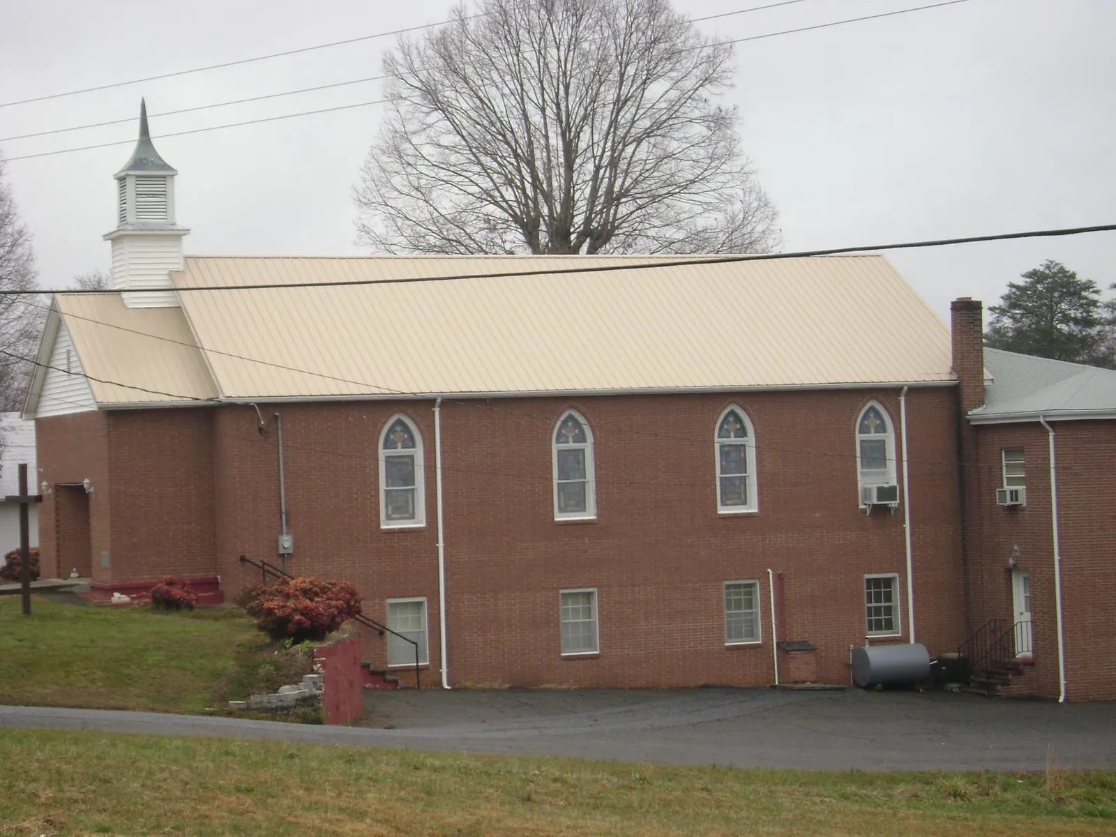 New tan metal roof on a brick church with a white steeple in Medical Lake