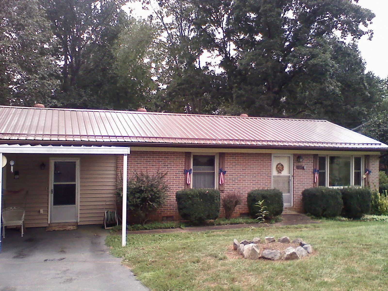 Bronze metal roof and carport on a brick ranch home — Roof Repair work by our crew in Medical Lake